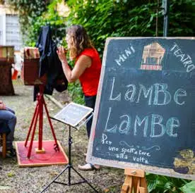 Una spettatrice osserva un teatro lambe lambe in miniatura